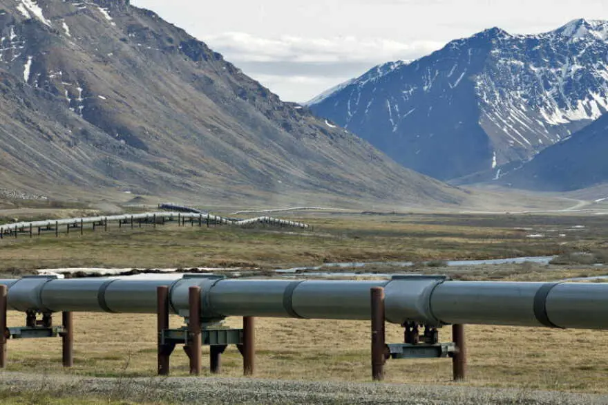 The Trans-Alaska Pipeline crossing the tundra below snow-capped mountains